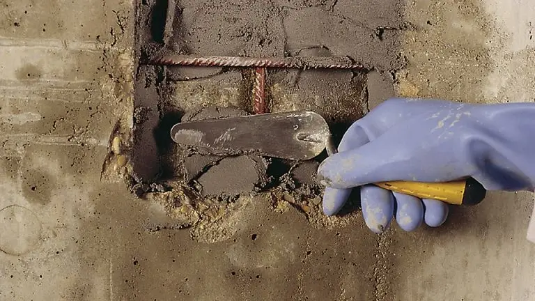 Applying mortar to damaged concrete for restoration, showcasing Concrete Rotorua's concrete repairs expertise.
