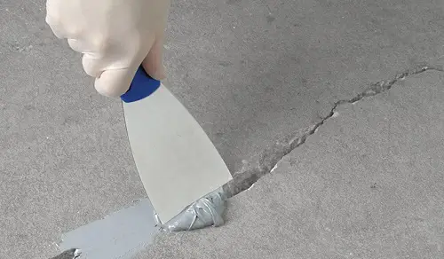 Applying sealant to fix a concrete crack, expertly handled by Concrete Rotorua for precise concrete repairs.